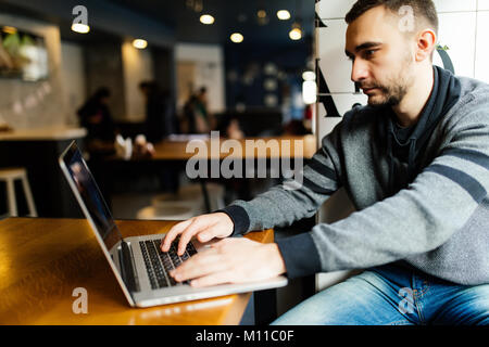 Smiling student using laptop in cafe at the university Stock Photo