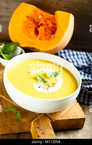 Pumpkin soup with basil and cream Stock Photo