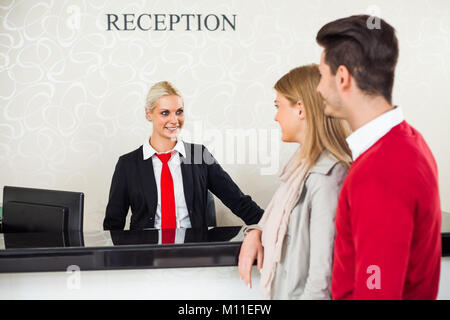 Young couple check in at hotel reception Stock Photo