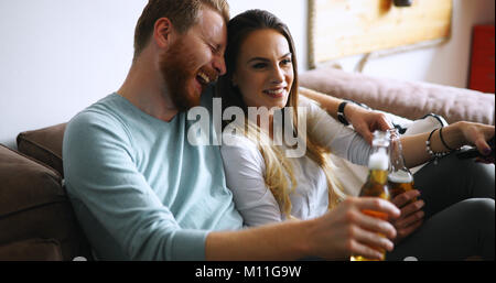 Happy couple drinking beer and toasting at home Stock Photo