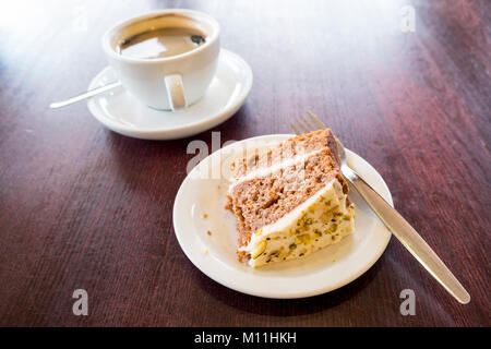 Black coffee and some partially eaten cake on a wooden table Stock Photo