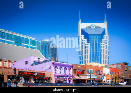 Famous honky tonks and bars line lower Broadway in Nashville, Tennessee, while being dominated by the AT&T skyscraper in Downtown Music City USA Stock Photo