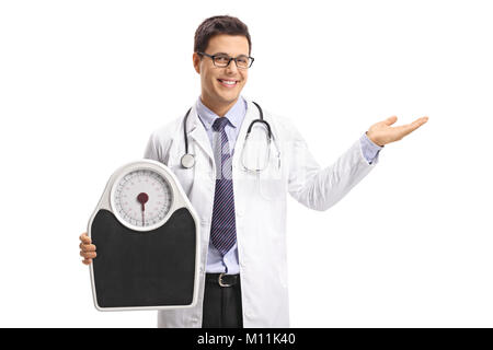 Doctor holding a weight scale and making a welcome hand gesture isolated on white background Stock Photo