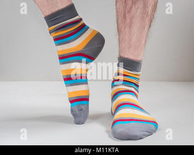 Men's feet in funny, colorful socks on a white background Stock Photo