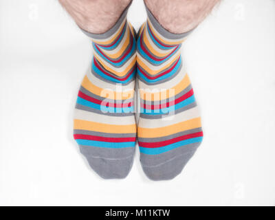 Men's feet in funny, colorful socks on a white background Stock Photo