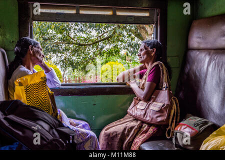 IDALGASHINNA, SRI LANKA - FEBRUARY 2: Two local ladies traveling by local train and looking thru the window. February 2017 Stock Photo
