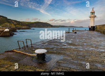 The iconic lighthhouse at Mevagissey harbour waiting to start it's 'night shift' alongside two harbourside mooring mushrooms. Stock Photo