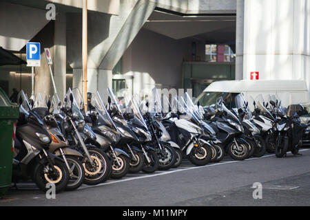 Genova, Italy - January 18, 2018: Modern scooters stand in a row on urban parking lot, photo with selective focus Stock Photo