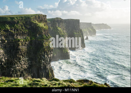 The Cliffs of Moher, Irelands Most Visited Natural Tourist Attraction, are sea cliffs located at the southwestern edge of the Burren region in County  Stock Photo