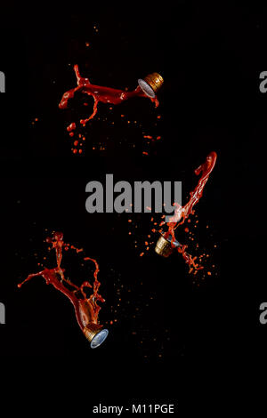 Coffee capsules with hot chocolate splashes flying isolated on a black background. Action food photography. Stock Photo