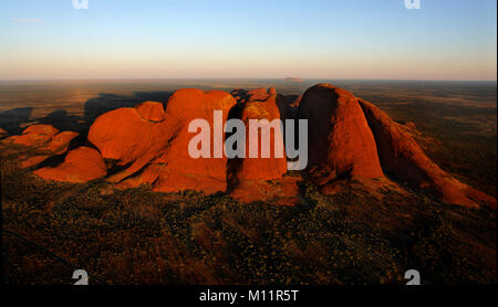 Uluru Kata - Tjuta National Park. Orange Uluru in bright beams of the sunset sun. Aerial photography. Monolith in the first beams of the sun.. Norther Stock Photo