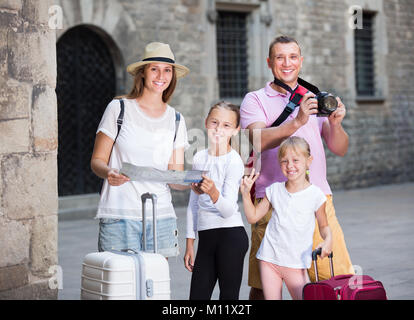 Young family with children using map and taking photo during their vacation Stock Photo