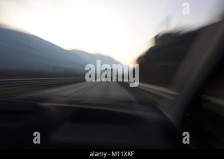 car traveling in the mountains with lorry ahead shot from passengers seat inside car Stock Photo