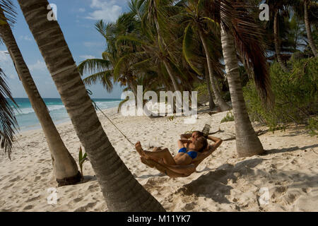 Mexico. Yucatan peninsula. Tulum. Palm trees. Couple relaxing in Hammock. Stock Photo