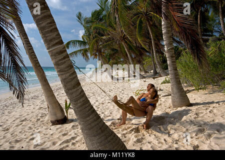 Mexico. Yucatan peninsula. Tulum. Palm trees. Couple relaxing in Hammock. Stock Photo
