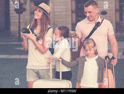 Smiling family with two kids using smartphone and photographing sights during their travel Stock Photo