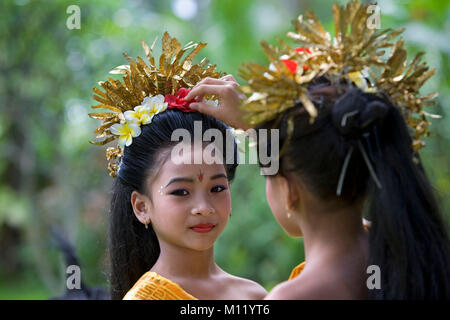 Indonesia. Sambirenteng. Island Bali. Young traditionnal Bali dancers (female) preparing headdresses. Stock Photo