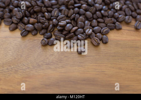 Roasted Coffee Beans Loosely Scattered on a Wood Table Stock Photo