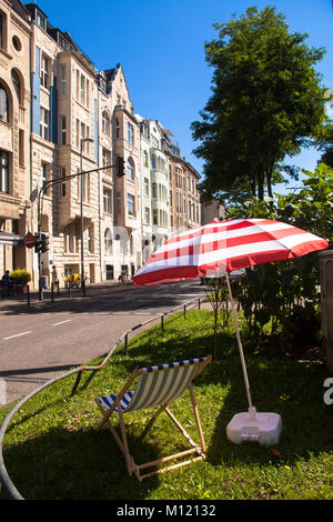 Germany, Cologne, houses at the street Ubrierring in the south part of the town, sunlounger and sunshade on a grass strip at a crossroads.  Deutschlan Stock Photo