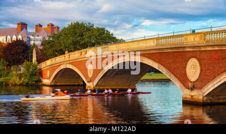 Harvard University sculling team early morning practice. Boat passes under a bridge on the Charles River in Cambridge, Massachusetts. Motion blur. Stock Photo