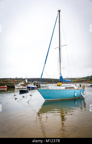 Blue yacht, Creyr Glas, moored in Cemaes Harbour on a calm evening Stock Photo