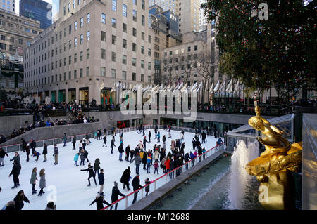 The ice skating rink in Rockefeller Center with the golden Prometheus sculpture in foreground.winter holiday season.Manhattan.New York City.USA Stock Photo