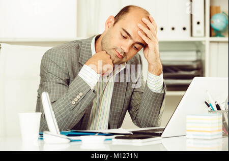 Male having lot of work and problems in the office Stock Photo