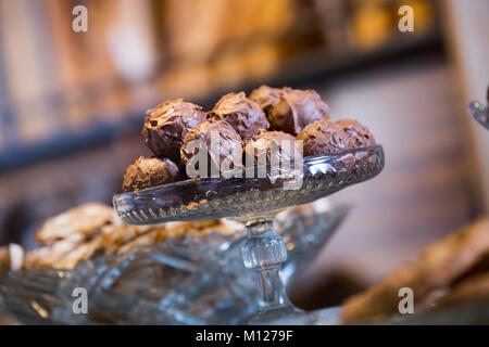 Sweet-stuff covered with chocolate syrup at bakery display Stock Photo