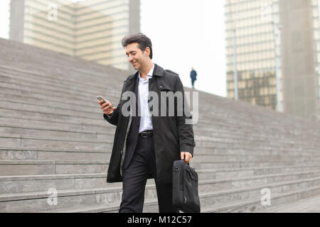 business man walking using smartphone to watch photos. Stock Photo
