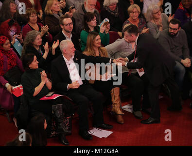 Labour leader Jeremy Corbyn (seated) congratulates Jonathan Ashworth MP, Shadow Health Secretary, after his speech at a rally at Westminster Central Methodist Hall in London, to demand that the Government introduces an emergency budget for the NHS to end the winter crisis. Stock Photo