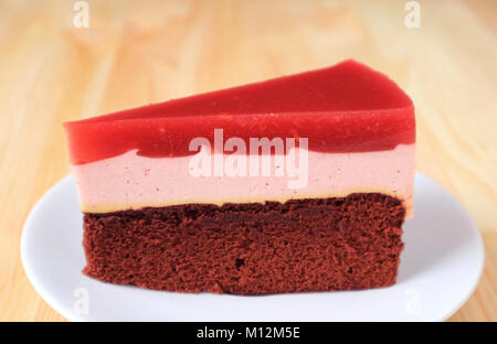 Front View of Raspberry Mousse with Chocolate Sponge Layer Cake Served on White Plate with Blurred Background Stock Photo