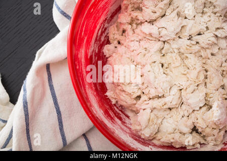 Making/mixing the dough in red bowl, baking preparation closeup. Stock Photo