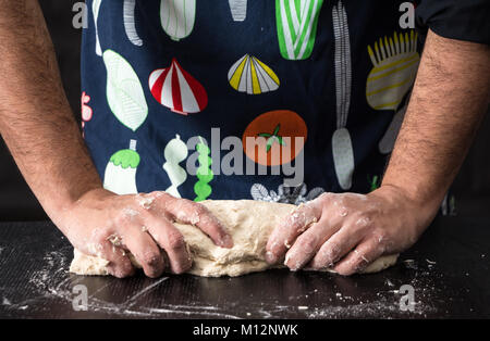 Male hands kneading dough, baking preparation closeup. Stock Photo