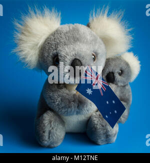 Koala Bear Holding Baby Koala And Australian Flag. Blue Background Stock Photo
