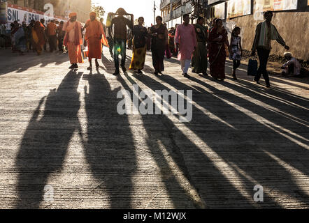 People walking in the street at Kumbh mela festival at sunset, India Stock Photo