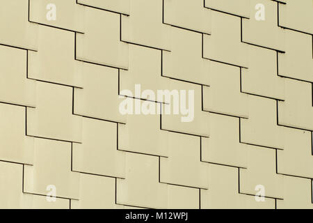 Abstract architectural background of overlapping cream-colored rectangular tiles in repeat rows in a full frame view Stock Photo