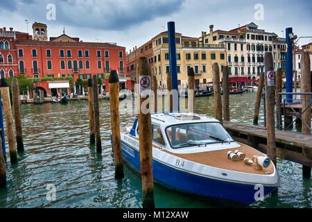 VENICE, ITALY - MAY 20, 2017: A boat on the docks of the Grand Canal with some beautiful old buildings behind in Venice, Italy. Stock Photo
