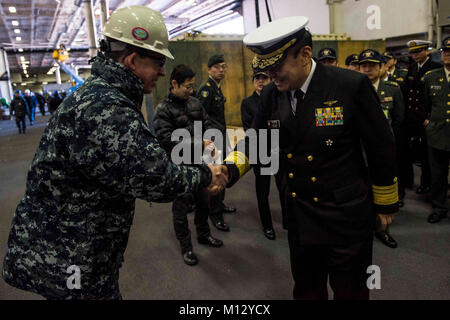 YOKOSUKA, Japan (Jan. 23, 2018) Capt. Buzz Donnelly, commanding officer of the Navy's forward-deployed aircraft carrier, USS Ronald Reagan (CVN 76), greets Vice Adm. Katsuto Deguchi, commandant, Joint Staff College, during a tour in the hangar bay. Ronald Reagan, the flagship of Carrier Strike Group 5, provides a combat-ready force that protects and defends the collective maritime interests of its allies and partners in the Indo-Asia-Pacific region.  (U.S. Navy Stock Photo