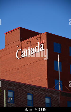 Brick Building with official Government sign "Canada" in front of a blue sky. Stock Photo
