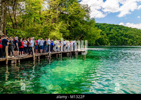 Tourists waiting to board the ferry on the boardwalk at Plitvice Lakes National Park, Croatia