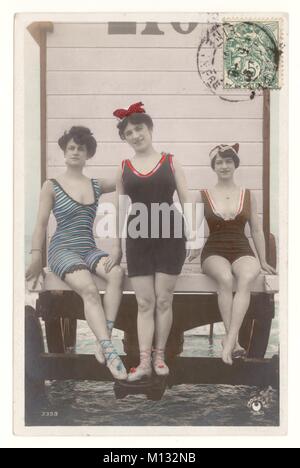 Edwardian tinted postcard of lady bathers sitting on bathing hut, posted from Dieppe, N. France, circa 1907  Retro beach photo postcard. Stock Photo