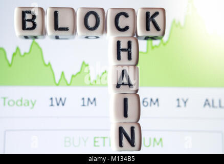 Small dices with letters writing Blockchain placed on phone screen Stock Photo