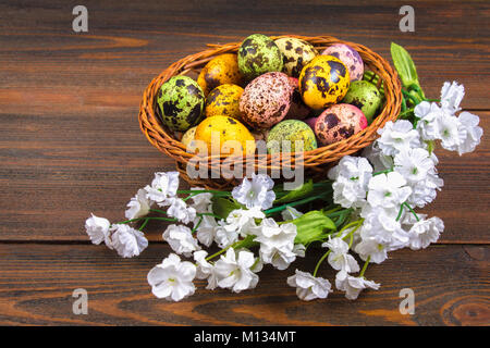 Quail multi-colored Easter eggs on a brown wooden table Stock Photo