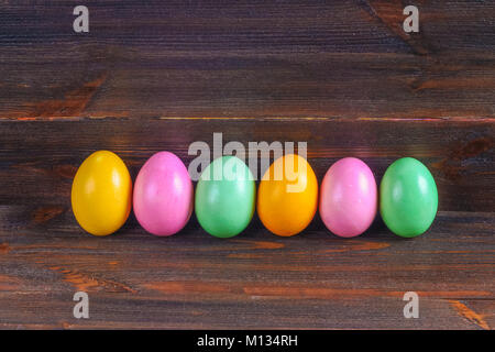 Multicolored easter eggs on a brown wooden table Stock Photo