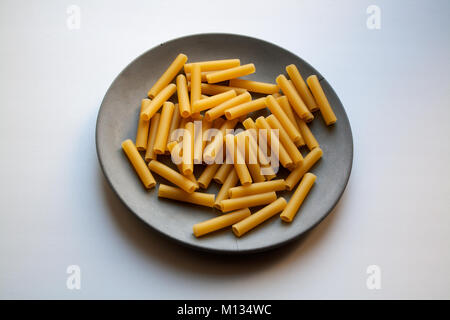 6878 Heap of cannelloni pasta isolated on grey concrete plate Stock Photo
