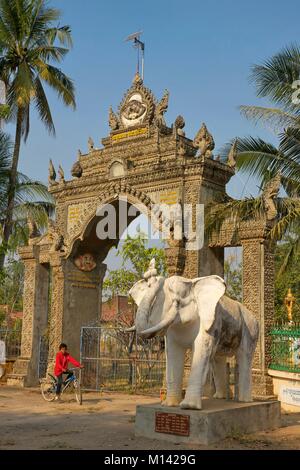 Cambodia, Battambang, bicycle kid in front of the buddist temple door and a elephant statue Stock Photo