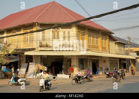 Cambodia, Battambang, scooters passing in front of french colonial buildings in a street crossed by electric wires Stock Photo