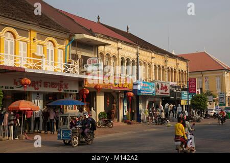 Cambodia, Battambang, scooters passing in front of french colonial buildings Stock Photo
