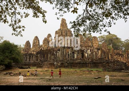 Cambodia, Angkor, listed as World Heritage by UNESCO, children playing in front of the Bayon, the main temple of the old khmer town of Angkor Thom Stock Photo