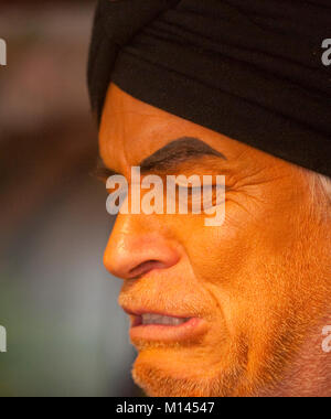 Orange faced man in a purple vest and black turban. Stock Photo